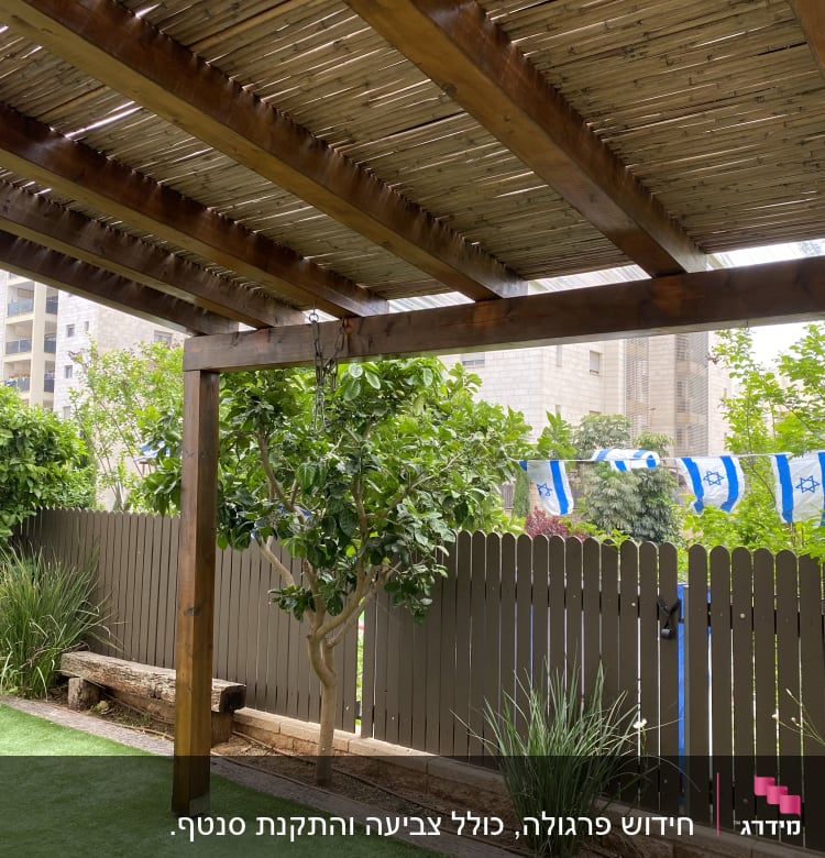 פרגולה מעץ עם גדר עץ ודגלים